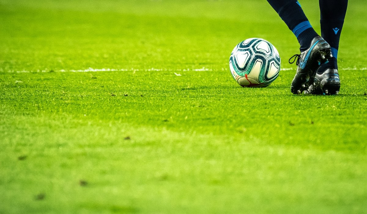 Soccer man on field with ball at feet